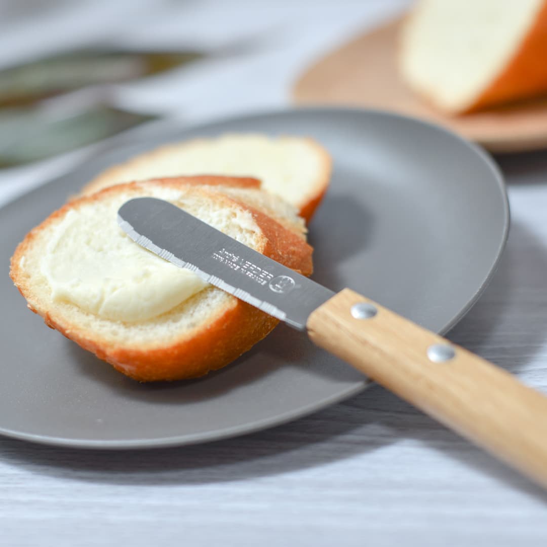 バターナイフでパンにクリームを塗っている写真1